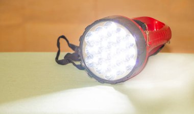 Beyaz ışık arka planında kırmızı bir el feneri.