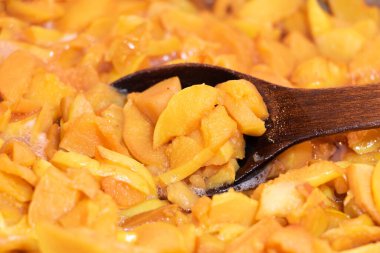 Ayva reçeli pişirme sürecinde. Ahşap kaşıkla reçel karıştırmak.