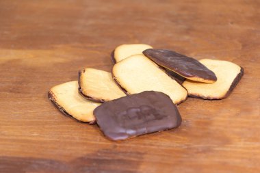 Çikolatalı bisküviler ve portakallı meyveler. Ahşap arkaplan.