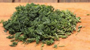 Doğranmış dereotu. Yemek pişirme sürecinde. Kesme tahtasındaki Dill