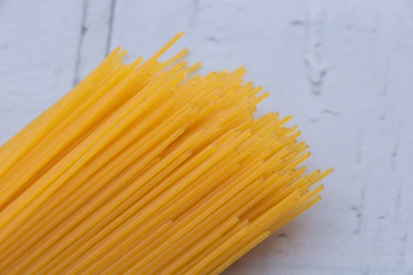Купка сирого італійського спагеті на дерев "яному фоні. — стокове фото