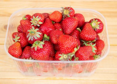 Ahşap arka planda taze ve lezzetli çilekler. Çileklerin faydaları.