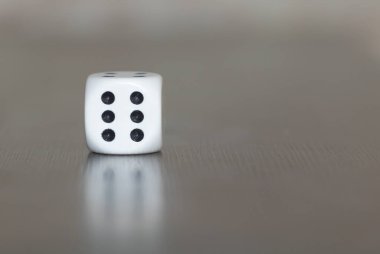 Gri arkaplanda tek bir zarın yakın plan çekimi