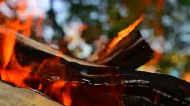 Açık havada yakacak odun ateşinden. Koyu bir arkaplana karşı yanan alevin yakın plan görüntüsü