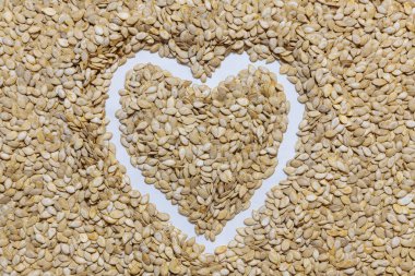 Balkabağı tohumları boldur. Bir kalp şeklinde serilmişti. Sağlıklı ve doğal yiyecekler..