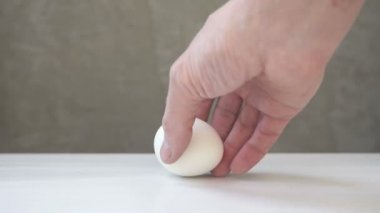 Beyaz tavuk yumurtaları beyaz bir masaya yerleştirilir. Gri arka planda gıda ürünü