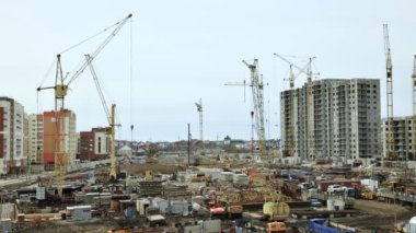 Barnaul şehri. - Rusya. Haziran 07.2021. Güçlendirilmiş beton ve tuğlalardan konut binaları inşa ediliyor. Kule vinç işi, ev ereksiyonu. Sanayi bölgesinin tutkuları. zaman turları 