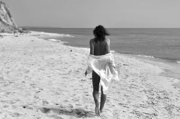 Girl walk on the wild beach in white shirt — Stock Photo, Image