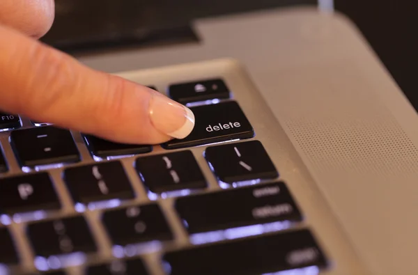 Female finger on the delete key