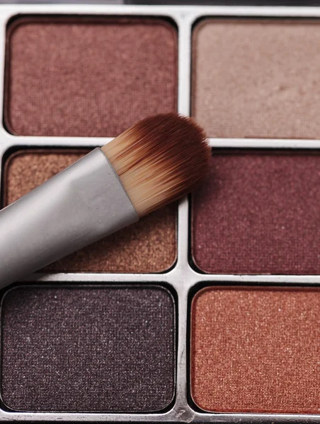 Cepillo de maquillaje sobre un fondo rústico texturizado —  Fotos de Stock