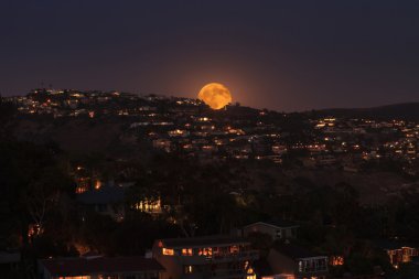 Ayın yükselişine dolunay Laguna Beach kıyı şeridi üzerinde