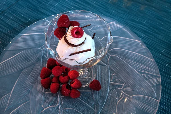 stock image Dessert dish of cheesecake, shaved chocolate and raspberries on a glass plate.