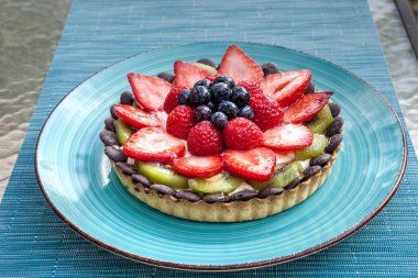 Kırmızı çilek, böğürtlen, kırmızı ahududu ve kivi içeren büyük meyveli tart..