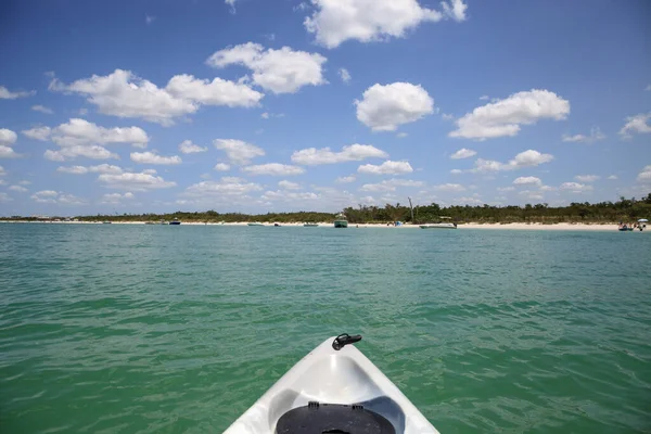 Blue sky over a boat and the beaches of Bonita Springs, Florida from the ocean.