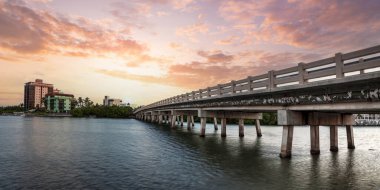 Güneşin batışı Hickory Geçidi 'nin üzerinde Bonita Springs, Florida' daki okyanusa açılıyor..