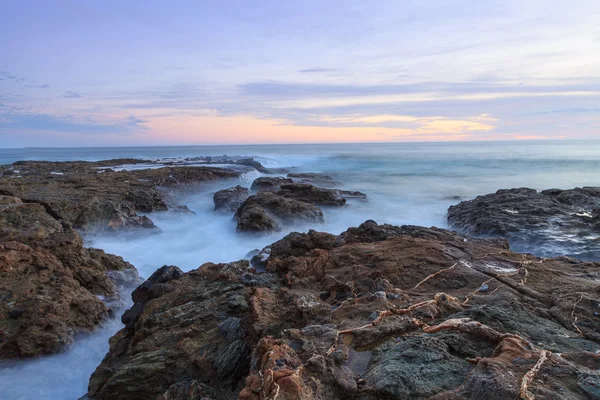 Água enevoada sobre rochas ao pôr do sol — Fotografia de Stock