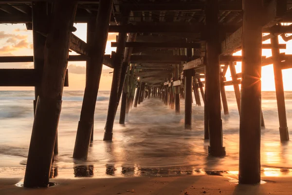 Under the San Clemente pier on the beach at sunset — Stock Photo, Image