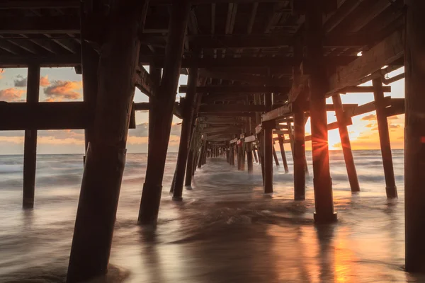 Under the San Clemente pier on the beach at sunset — Stock Photo, Image