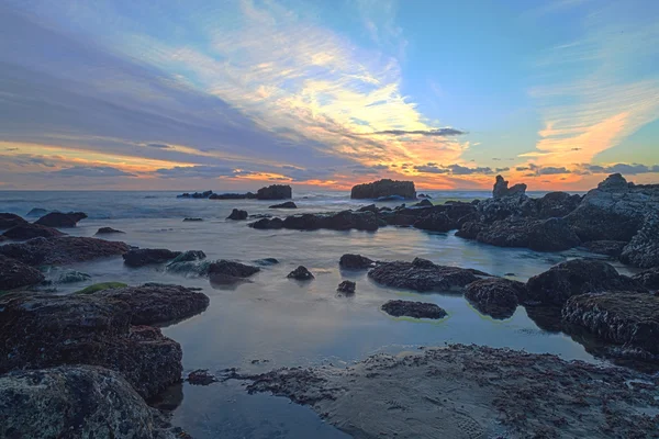 Long exposure of sunset over rocks — Stock Photo, Image