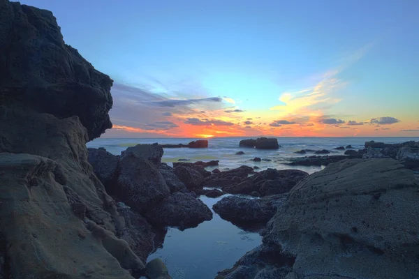 Longa exposição do pôr do sol sobre as rochas — Fotografia de Stock