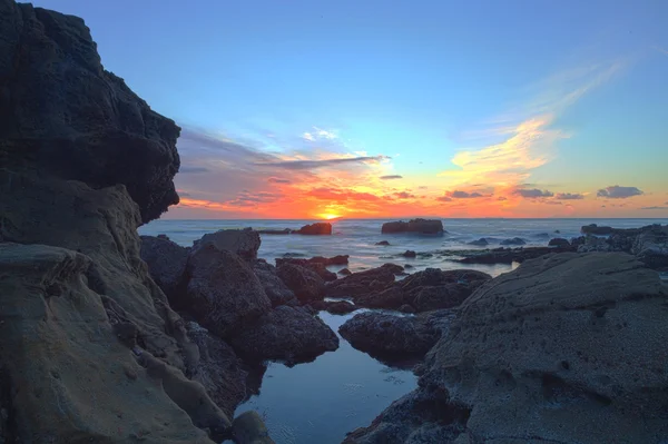 Longa exposição do pôr do sol sobre as rochas — Fotografia de Stock