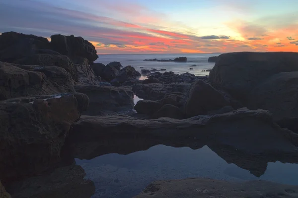 Long exposure of sunset over rocks — Stock Photo, Image