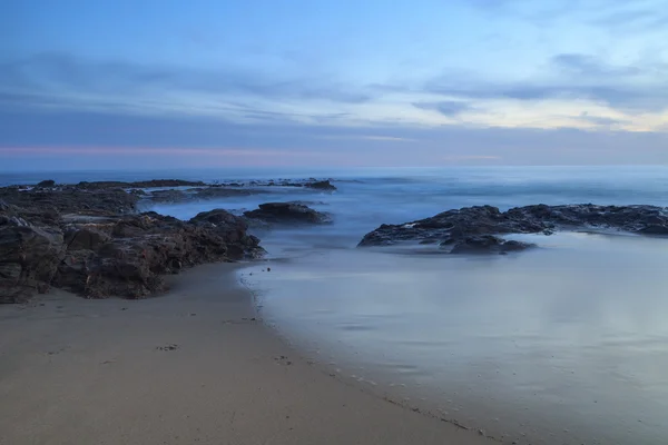 Long exposure at sunset over rocks — Stock Photo, Image