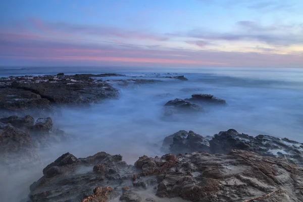 Long exposure at sunset over rocks — Stock Photo, Image