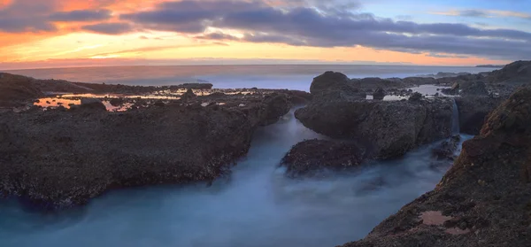 Long exposure at sunset over rocks — Stock Photo, Image