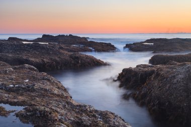 Günbatımı Laguna Beach kayalar üzerinde uzun pozlama