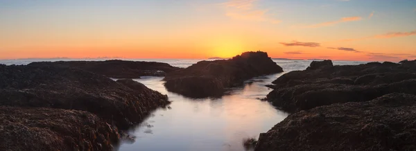 Long exposure of sunset over rocks in Laguna Beach — Stock Photo, Image