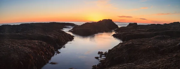Long exposure of sunset over rocks in Laguna Beach — Stock Photo, Image