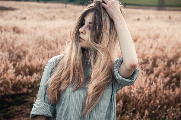 Menina bonita e jovem na camisa de um homem em pé no campo — Fotografia de Stock