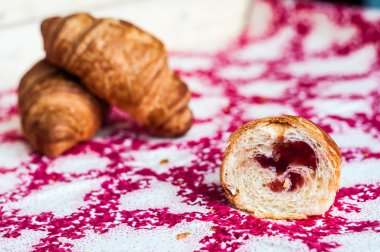 Half a croissant, big, delicious croissants on a table. Fresh ba