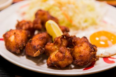 Kızarmış tavuk ve yumurta beyaz plaka üzerinde kızarmış.