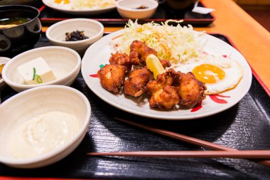 Kızarmış tavuk ve yumurta beyaz plaka üzerinde kızarmış.