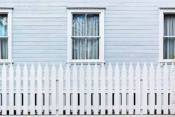 White wooden country style fence with windows of house — Stock Photo, Image