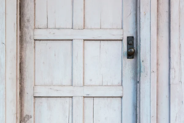 Кнопка двери на старой белой деревянной двери — стоковое фото