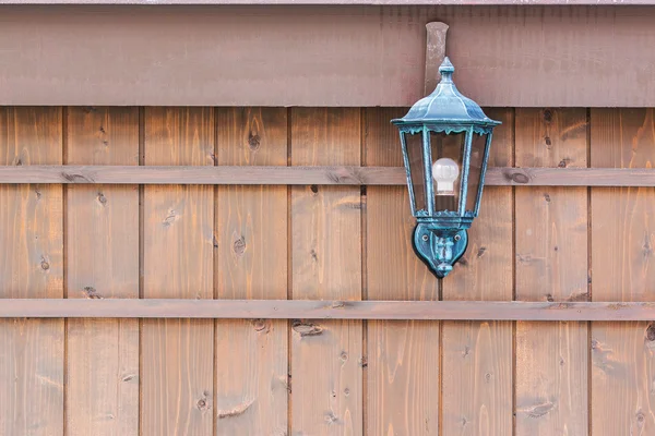 Старомодный фонарь на коричневой деревянной стене . — стоковое фото