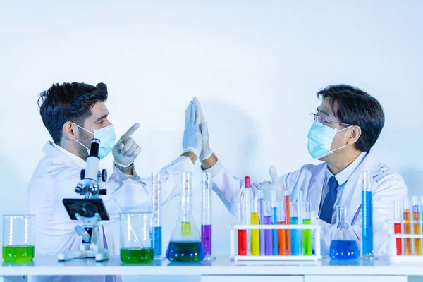 Couple male scientist handshake for success teamwork at laboratory. Scientist portrait shot