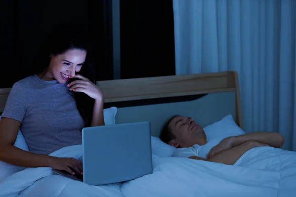 Donna Seduta Sul Letto Notte Utilizzando Computer Portatile Mentre Marito — Foto Stock