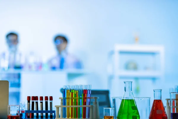 Laboratory Research - Scientific glassware with blur scientist researching background.