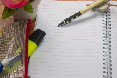 Boş yere sarf malzemeleri ve çiçek ile bir not defteri. C ile Üstten Görünüm