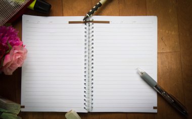 Boş yere sarf malzemeleri ve çiçek ile bir not defteri. C ile Üstten Görünüm