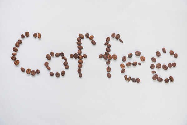 Inscription "coffee" from coffee grains on a white background