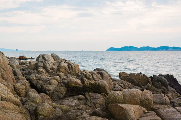 Pietre costiere e onde marine sopra il cielo nuvoloso in estate — Foto Stock