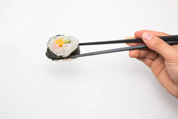 Sushi roll met zwarte stokjes geïsoleerd op witte achtergrond. — Stockfoto