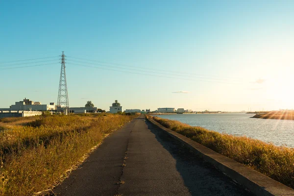 日没時に川沿いの道路. — ストック写真