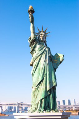 Lady liberty juxtaposed stand near Rainbow Bridge in Odaiba clipart