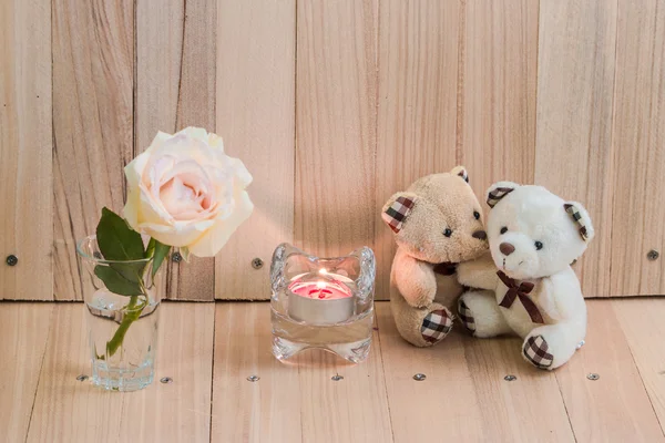 Niedźwiedzi uścisk w pobliżu Świecznik i pastelowych Rose — Zdjęcie stockowe